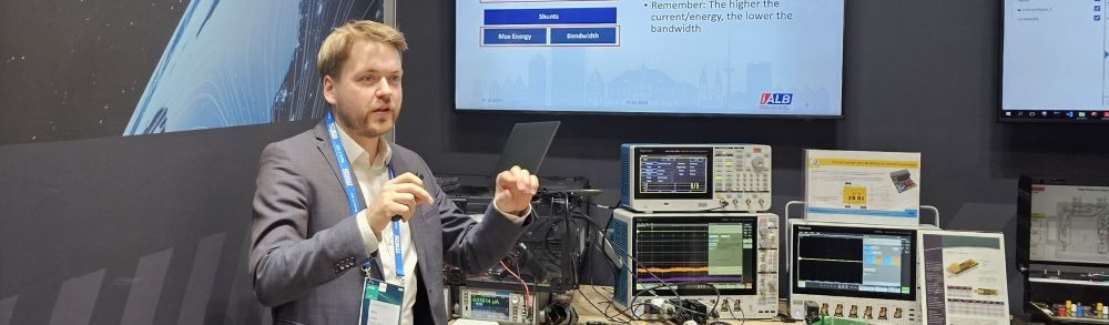 Hauke Lutzen presenting a technical tutorial at the Tektronix booth during PCIM 2025 power electronics exhibition.